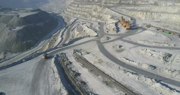 Flycam Follows Truck Driving To Excavators on Asbestos Pit