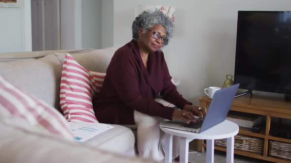 Senior african american female doctor having a video call on laptop at home