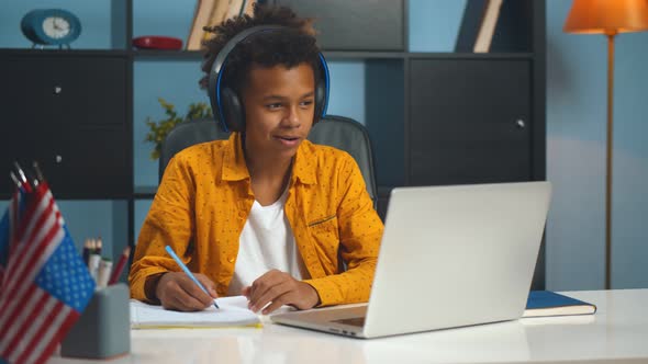 Preteen Afro Schoolboy Doing Homework with Laptop at Home