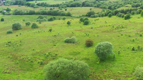 Drone footage over vibrant green farmland and fields