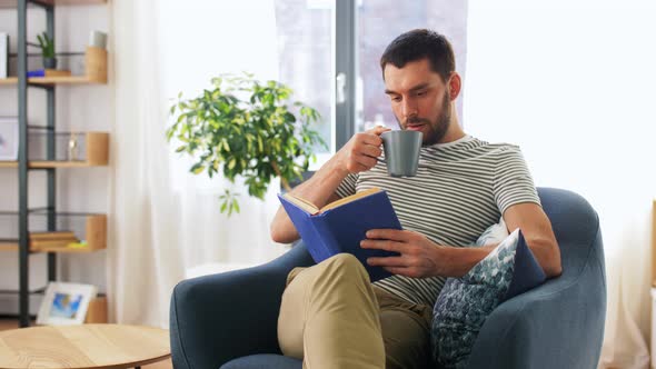 Man Reading Book and Drinking Coffee at Home