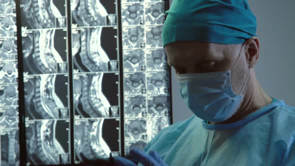 Exhausted Male Surgeon Taking Off Medical Gloves and Face Mask Long Operation