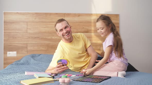 Dad and Daughter are Preparing for Halloween are Going to Do Bright Makeup