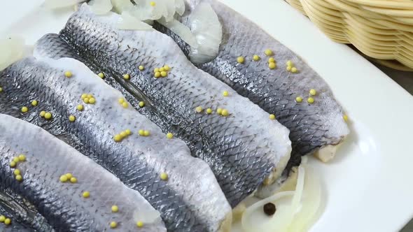 Traditional Dutch sour herring with onions and mustard seed close up 