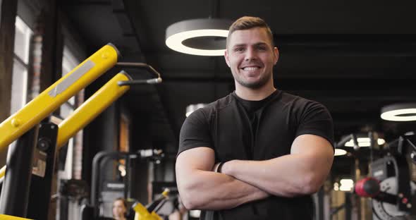 Portrait of a Handsome Athletic Man Wearing a Black Tshirt Smiling Who is Resting After a Strength