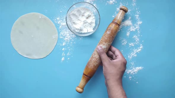 Hands Baking Dough with Rolling Pin on Table Top View
