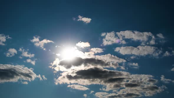 Clouds Move Smoothly in the Blue Sky on Background of Bright Sun. Timelapse