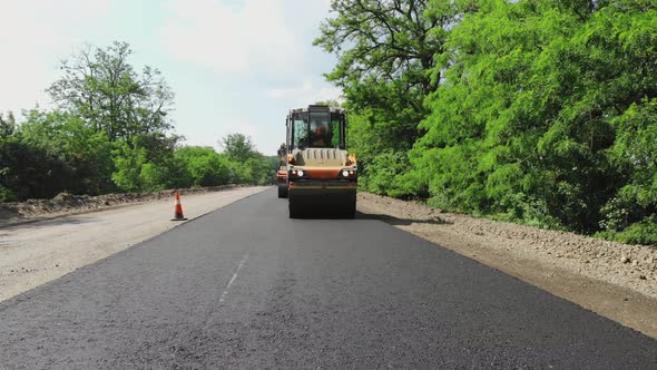 Repair of a Highway Roller Compactor Machine and Asphalt Finisher Laying a New Fresh Asphalt