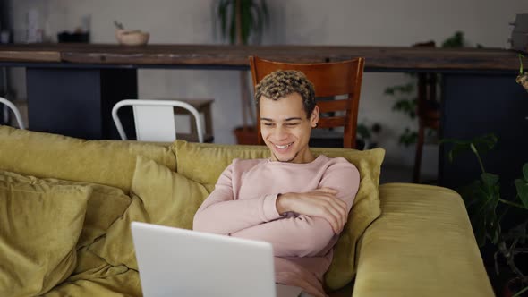 Happy Young Man Laughing Talking to Friends on Video Conference or Watch the Show