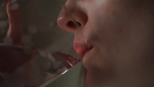 Woman with Pleasure, at Home in the Room Drinks Water From a Glass Goblet