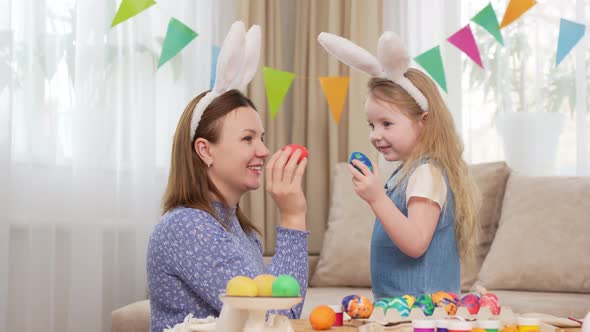 Mother and Sweet Daughter Play with Easter Eggs in Game of Who Will Break