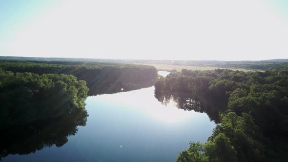 Aerial Video of the Lake on a Warm Summer Day in Light of the Setting Sun