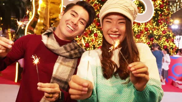 Merry Christmas and Happy New Year. Young  asian couple with Christmas lights