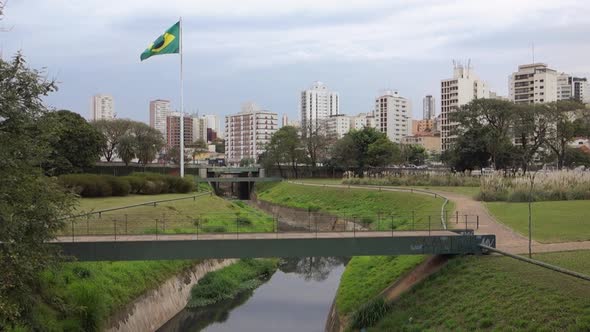 brazilian flag waving in the wind, besides the Ipiranga stream, in the Independence Park. Sao Paulo,