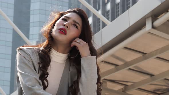 Lay off concept. Fired business woman sitting on stairs of office building outside. Depressed