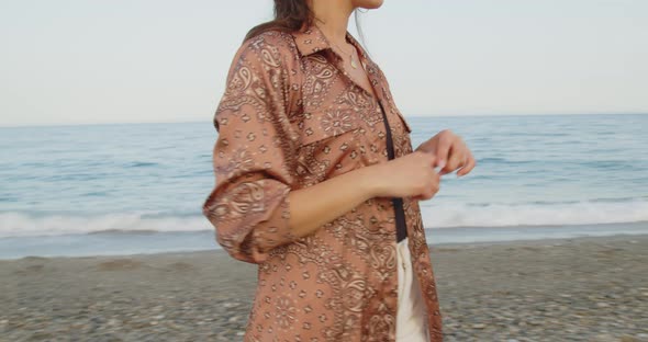 Young girl with black boots has fun on the beach near the sea in Italy