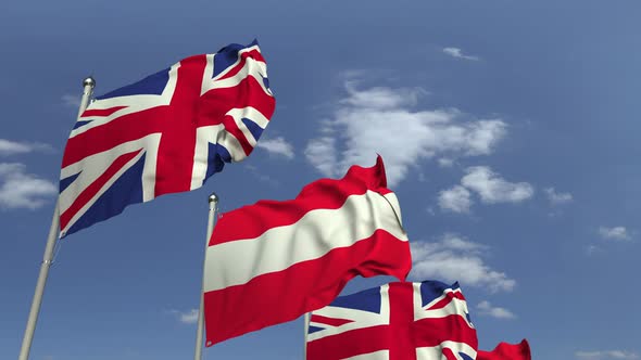 Waving Flags of Austria and the UK on Sky Background