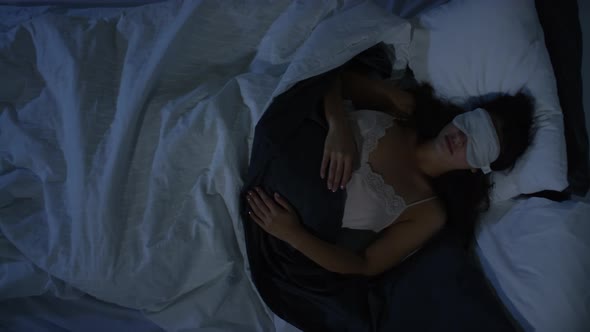 Top View of Woman in Eye Mask Sleeping in Dark Bedroom