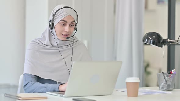 Young Arab Woman with Laptop Talking on Headset