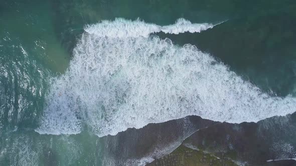 Large Ocean Waves with White Foam Roll on Yellow Beach