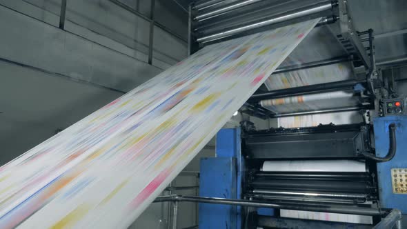 Printing Equipment with Coloured Paper Rolling Along. Newspaper Printing at a Printing Facility.