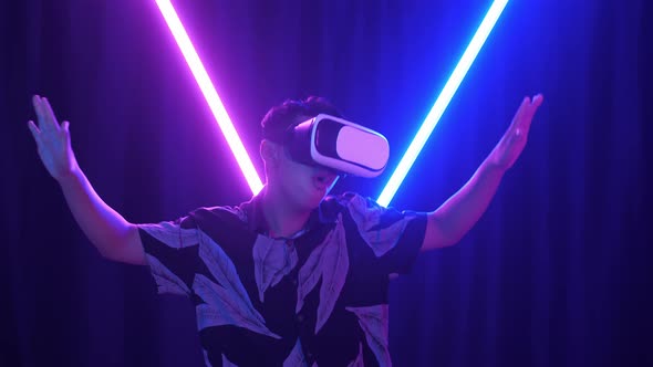 Excited Asian Boy Using Virtual Reality Headset And Funny Dance With Neon Light At The Background