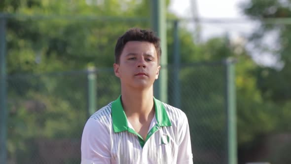 A Young Man Tosses a Tennis Racket