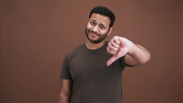 Unhappy Indian Guy Gesturing Thumbs Up with Both Hands Expressing Disapproval Brown Studio