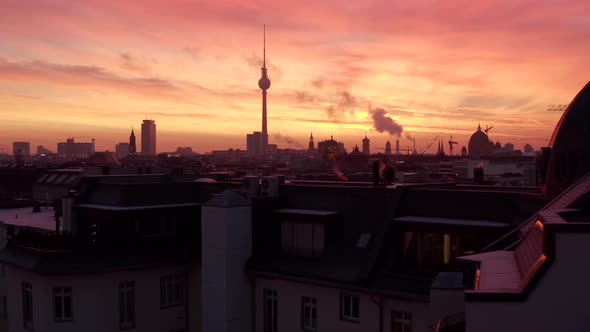 Low flight over Berlin Rooftops with Fire Red Sunset or Sunrise