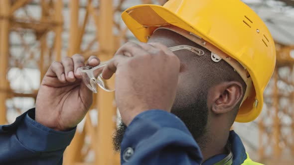 Black Male Worker Putting On Safety Goggles