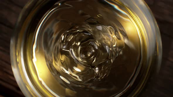 Super Slow Motion Macro Shot of Dripping Droplet Into Filled Glass of White Wine at 1000Fps