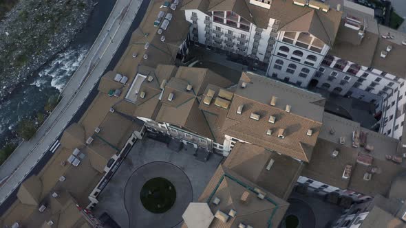 Aerial View Flying Over Shine Roofs Touristic Hotel Area Surrounded By Mountains Valley