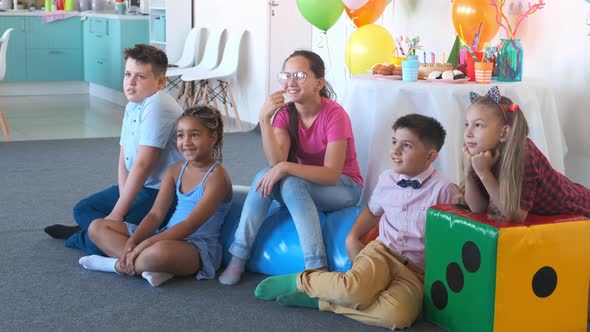 AfricanAmerican Girl with Friends Enjoys Show at Birthday