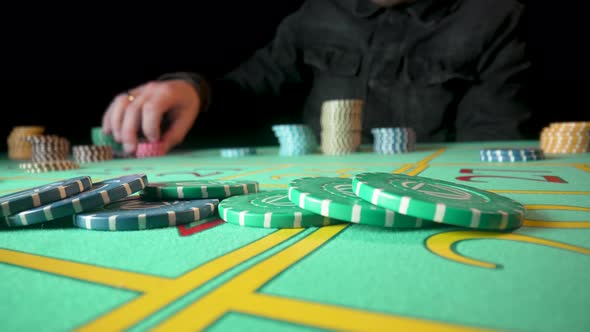 Unrecognizable Male Gambler Makes Bets While Sitting at Roulette Table in Casino