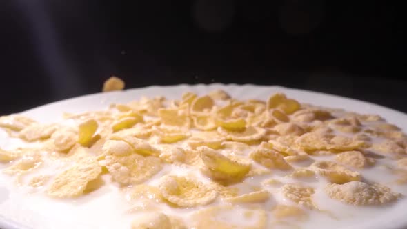 Yellow Corn Flakes Fall in a White Plate with a Pattern of Flowers on the Edge and Are Filled with