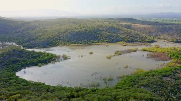 Panoramic Mountainous Aerial View as Sunlight Reflects on Mangrove Forest Waters, Azua Province, Dom