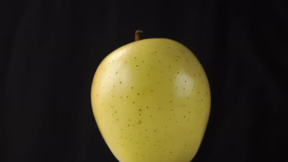 Close-up green ripe apple on a dark crumpled paper background. 