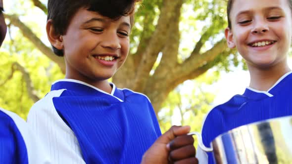 Kids holding winner trophy in park alt