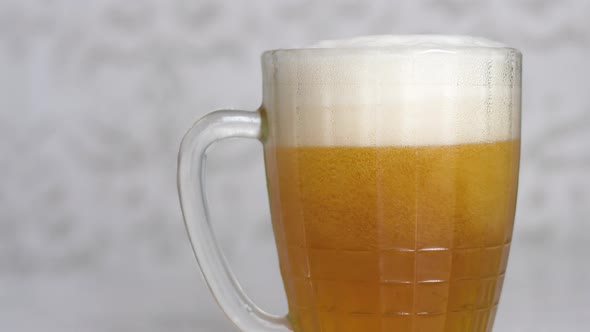 foamy light beer is poured into a large bar mug to the brim, the hand takes a beer glass. beer bar, 