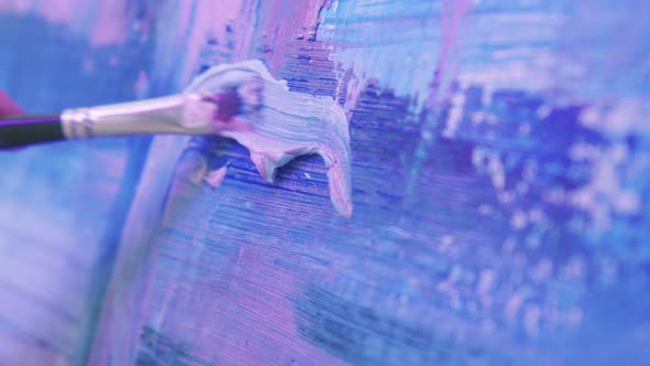 A Woman Paint Artist Drawing an Abstract Painting in Blue and Lavender Tones with a Brush and Oil