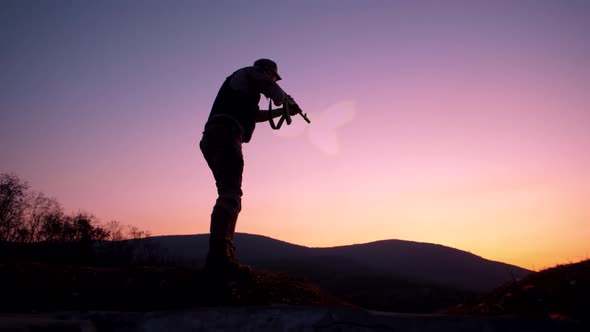 Rifle shooting against a beautiful pink sunset