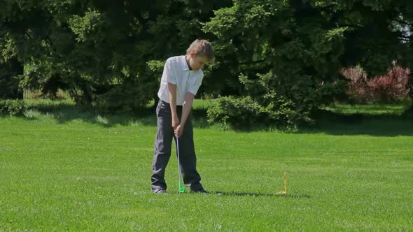 The boy plays golf.