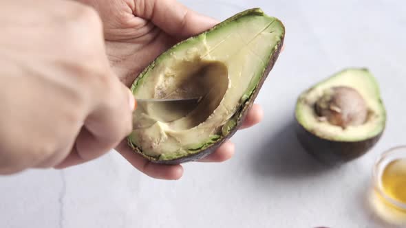 Women Hand Cutting Slice of Avocado with Knife