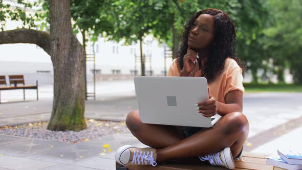 African Student Girl with Laptop and Books in City