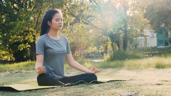 Attractive Asian woman sitting in meditation pose position yoga.