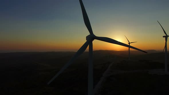 Close up aerial view of windmill blades at sunset