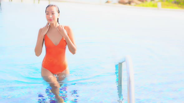 Young asian woman enjoy around outdoor swimming pool for leisure