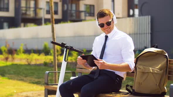 Businessman with Tablet Pc, Headphones and Coffee