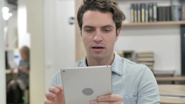 Man Celebrating Success While Using Tablet