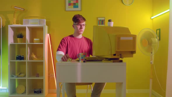 Young Man Is Sitting At Workplace and Scrolling Computer Mouse